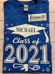 Class of 2021 celebrate your favorite Grad with this stylish graduation t-shirt. Add your graduate's name and graduation year. Youth and Adult Shirt colors: Black, White, Gray, Red, Navy, Royal Blue, Purple, Green, Orange, Maroon, Gold Toddler Shirt Colors: Black, Navy, Red, Royal, White Imprint colors: Silver, Gold, White, Black, Red, Navy, Royal Blue, Green, Purple, Orange, Maroon Sizes: Adult Small - 4X-Large Youth X-Small - XLarge Toddler: 2T, 3T, 4T Select colors available. How to Order Sel Blue Crew Neck T-shirt For School Events, Cotton T-shirt With Custom Print For Graduation, Crew Neck Tops For Graduation, Cotton Crew Neck T-shirt For Graduation, School Spirit Crew Neck T-shirt For Graduation Party, Graduation Crew Neck T-shirt With Letter Print, Graduation Cotton T-shirt With Letter Print, Graduation Gift Short Sleeve T-shirt With Text Print, Graduation Gift T-shirt With Text Print, Crew Neck