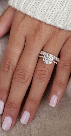 a woman's hand with two engagement rings on it