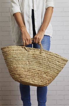 a woman is holding a large woven basket