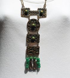 This handsome, handmade mixed metal necklace was produced by Casa Maya Mexico.  The necklace was well-made, and is stamped MEXICO on the back.  Metals include copper and brass, plus dyed green onyx stones and green plastic beads. The necklace has four pendant drops composed of a combination of green onyx beads, green plastic beads on the outer sides, and copper and brass arrow-shaped components.  All links in the neck chain are soldered closed.  Estimated age is the 1950s - 1960s -- mid century Vintage Green Copper Jewelry, Green Vintage Copper Jewelry, Green Artisan Necklace With Patina, Artisan Green Necklace With Patina, Bohemian Patina Necklaces Collectible, Unique Green Patina Necklaces, Artisan Green Metal Necklace, Artisan Green Copper Necklace, Vintage Hand Forged Green Jewelry