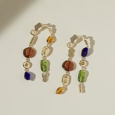 Guaranteed to get a second look, these stunning earrings almost dust your shoulders at 3 long. The Avery Earrings feature 8 colored glass beads that glisten in the sunlight. The rainbow pallet was thoughtfully chosen for adding pops of color while still being versatile enough to compliment any outfit. Each metal charm is cast, polished, and assembled by hand. These earrings are a true work of art for your ears! - gold plated brass - czech glass - hypoallergenic Modern Multicolor Dangle Jewelry, Elegant Rainbow Earrings, Modern Multicolor Single Earring, Modern Jewelry With Colorful Beads, Elegant Long Drop Colorful Beads Jewelry, Elegant Multicolor Long Drop Beaded Earrings, All That Glitters, Stunning Earrings, Metal Charm