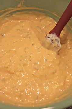 a wooden spoon mixing batter in a green bowl