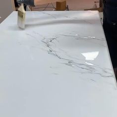 a man is painting a white marble counter top