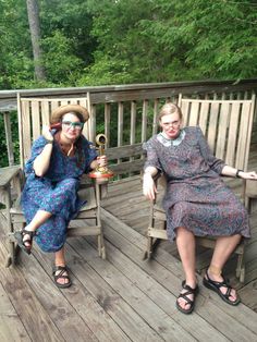 two women sitting on wooden porches with trees in the background and one holding a trophy