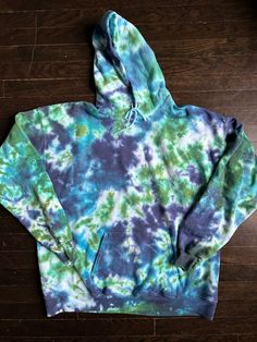 I tie dyed this size XL adult hoodie in a green and blue tie dye scrunch pattern.  Shirt is 50/50 cotton and polyester blend.  If you need a different size please message me and I would be happy to make you a custom hoodie.   I use high quality fiber reactive dyes that stay bright wash after wash.  Machine wash and dry with like colors. Tie-dye Hooded Top With Drawstring, Hand Dyed Blue Cotton Sweatshirt, Blue Hand Dyed Cotton Sweatshirt, Cotton Tie-dye Hoodie Sweatshirt, Tie Dye Cotton Hooded Sweatshirt, Hand Dyed Long Sleeve Blue Sweatshirt, Hand Dyed Blue Long Sleeve Sweatshirt, Blue Hand Dyed Long Sleeve Sweatshirt, Blue Hand-dyed Long Sleeve Sweatshirt