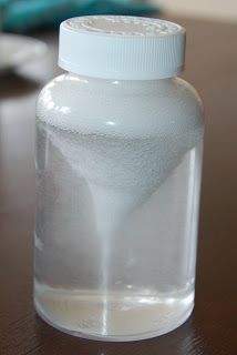 a glass bottle sitting on top of a wooden table