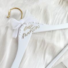 a white wedding hanger with the word mr and mrs written in gold on it