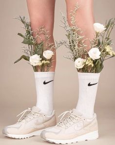 a pair of white nike sneakers with flowers in them and socks on the legs that are attached to their ankles