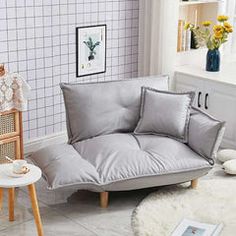 a living room filled with furniture and white tiles on the walls, along with a rug