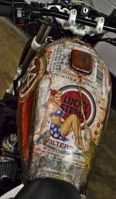 the back end of a motorcycle with an old advertisement on it's side panel