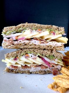 a sandwich cut in half sitting on top of a plate next to chips