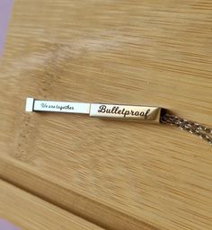 Celebrate the power of unity with this Bulletproof Bar Necklace, a sleek and meaningful accessory for BTS fans! This hidden message necklace is the perfect blend of subtle style and emotional connection, making it a thoughtful gift for yourself or your fellow ARMY. Hidden Message: Engraved with the heartfelt words, "We are together," the message is a reminder of the bond shared between BTS and their fans--a beautiful sentiment for any occasion. Unisex Design: Made for all BTS lovers, this minimalist bar necklace has a modern, unisex design that complements any outfit, whether you're dressing up or keeping it casual. Premium Quality: Crafted from durable stainless steel, this necklace is tarnish-resistant and hypoallergenic, ensuring long-lasting wear. This fanmade necklace is perfect as a Customizable Minimalist Bar Necklace As Gift, Modern Bar Necklace For Everyday Wear, Minimalist Customizable Bar Necklace For Gifts, Boys Necklace, Custom Bar Necklace, Message Necklace, Minimalist Bar, Engraved Bar Necklace, Hidden Messages