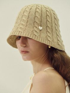 a woman wearing a knitted hat with hearts on the front and back of it