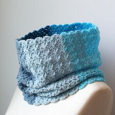 a crocheted blue and gray scarf on top of a mannequin head