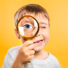 a young boy looking through a magnifying glass