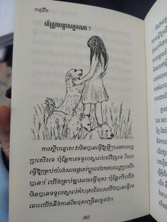 an open book with a drawing of a girl holding a dog in it's hand