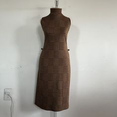 "Introducing a true vintage gem from the 1970s - the brown and gold glittery houndstooth pattern sleeveless dress by Sharagano Paris. This stunning dress is a rare find that will add a touch of retro glamor to your wardrobe. This dress features a unique houndstooth pattern in a warm brown and gold glittery hue that shimmers in the light. The sleeveless design allows for easy movement, while the fitted silhouette accentuates your curves for a flattering fit. The dress also features a high necklin Retro Sleeveless Winter Dresses, Brown Fitted Sleeveless Dress For Work, Fitted Sleeveless Brown Dress For Work, Fitted Brown Sleeveless Dress For Work, Retro Brown Dress For Fall, Retro Brown Midi Dress, Brown Sleeveless Knee-length Dress For Work, Brown Knee-length Sleeveless Dress For Work, Fitted Brown Sleeveless Dress For Fall