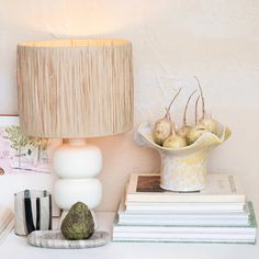 a lamp sitting on top of a table next to a pile of books and other items