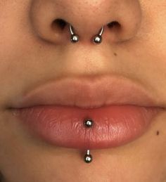 a woman's nose has three piercings on it