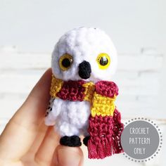 a small white owl wearing a red and yellow scarf