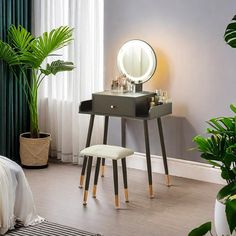 a vanity table with a mirror and stool next to a potted palm tree in a bedroom