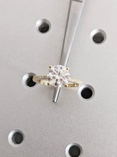 a diamond ring is sitting on top of some holes