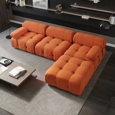 an orange couch sitting in the middle of a living room