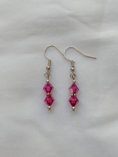 These earrings are made with headpins and earrings hooks. They contain small round silver beads, silver flower spacers, and magenta Swarovski bicone crystals. Swarovski Pearl Necklace, Swarovski Beads, Butterfly Bracelet, Beaded Jewelry Patterns, Head Pins, Swarovski Earrings, Jewerly Diy, Elegant Necklaces, Swarovski Pearls