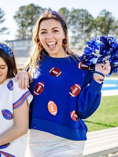 The Millie Sweatshirt features sparkling sequin footballs, radiating team spirit. Crafted from a lighter-weight version of our best-selling sweatshirt, the Millie offers a cool and comfortable alternative for those sunny game days and cool game nights. Model is 5’7” and wearing size S. Sizing: XS = 2-4 | Bust 34”-36", Waist 25”-27”, Hips 35"-37" S = 6-8 | Bust 36"-38", Waist 29"-31", Hips 37"-38.5" M = 8-10 | Bust 39"-41", Waist 31"-33", Hips 39"-41" L = 12-14 | Bust 41"-43", Waist 33"-35", Hips 41"-43" XL = 16-18 | Bust 48"-50", Waist 40"-44", Hips 50"-52" XXL = 20-22 | Bust 52"-56", Waist, 46"-48", Hips 54"-56" Details: Slightly cropped length Full volume sleeves Sequin embellished football icons Fabric is a light weight version of our classic soft sweatshirt Overall relaxed fit 83% Poly Volume Sleeves, Full Volume, Embellished Sweatshirts, Game Nights, Summer Pajamas, Id Wallet, Go Bags, Summer Set, Short Pajama Set