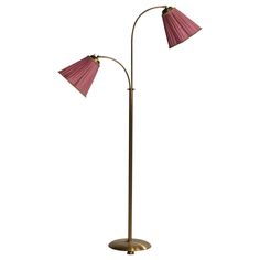 two light floor lamp with pink shades on the top and bottom, in an antique brass finish