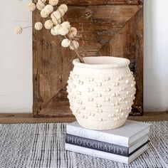 a white vase sitting on top of two books