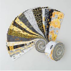 a bunch of different types of fabrics on a white surface with one rolled up and the other folded down