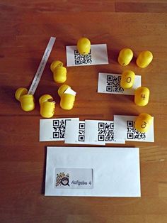 some yellow rubber ducks sitting on top of a wooden table next to qr code cards