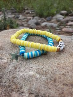 Summer may have ended, but we can keep the spirit alive with these bright, cheerful, and summery bracelets! ☀️ Picture yourself strolling along the beach, sipping on a cool drink, and flaunting these bracelets that scream summertime joy. 🏖️ Starstruck in Blue: One bracelet in this dynamic duo boasts a dazzling ocean blue hue, a true homage to those clear summer skies. Adorned with a twinkling star charm, it's your very own piece of the night sky right at your wrist. Whether you're a dreamer or just love a little celestial bling, this one's for you! 🌟 Here Comes the Sun: The second bracelet is a cheerful burst of sunshine itself! In radiant yellow, it practically screams sun! It's the perfect reminder to soak up these last rays and seize the day. Plus, you can wear these fabulous bracelet Turquoise Beaded Bracelets For Beach Party In Summer, Beachy Summer Bracelets With Letter Beads, Fun Beaded Stretch Bracelet For Beach, Summer Letter Bead Strand Bracelets, Summer Letter Beads Strand Bracelet, Fun Beach Stretch Bracelet With Round Beads, Yellow Beaded Bracelets For Beach With Colorful Beads, Beachy Beaded Bracelets For Friendship In Summer, Colorful Beaded Bracelets For The Beach