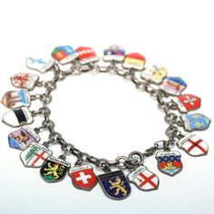 Discover a captivating journey through Europe with this vintage silver charm bracelet adorned with 20 enameled plaques showcasing iconic European cities. A wearable keepsake of wanderlust and nostalgia, this charm bracelet captures the essence of each city's charm and allure. Measuring 6.75 inches in length and weighing 28.2 grams, this bracelet exudes a delightful balance of elegance and substance. Each enameled plaque is a miniature work of art, capturing the essence of its city with intricate Silver Enamel Jewelry Souvenir, Vintage Enamel Charms Jewelry, Silver Enamel Bracelet, Silver Enamel Charm Bracelet, Silver Enamel Charm Bracelets, Silver Enamel Bracelets With Charms, Silver Charm Bracelets With Enamel, Silver Enamel Jewelry With Vintage Charm, Vintage Charm Bracelet