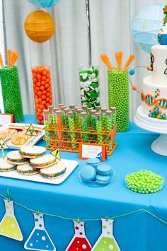 a blue table topped with lots of cakes and desserts