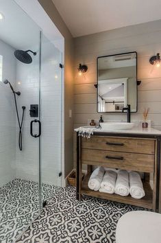 a bathroom with a sink, mirror and shower stall