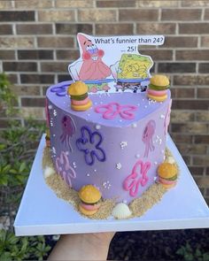 someone holding up a cake decorated with cartoon characters