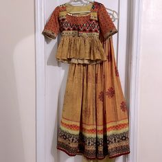 Indian Print Lehenga With Peplum Blouse. Blouse Has High Neck With Coin Detailing. 3/4th Sleeve. New, Never Worn. No Dupatta Yellow Bohemian Saree Set, Bohemian Yellow Saree Set, Yellow Bohemian Festive Sets, Festive Yellow Block Print Set, Bohemian Festive Yellow Set, Traditional Yellow Block Print Sets, Yellow Bollywood Cotton Choli, Yellow Bohemian Lehenga For Festive Occasions, Bohemian Yellow Sets With Block Print