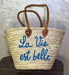 Embark on your sun-soaked adventures with the elegance of our Morocco Basket - your ideal companion for those idyllic beach days and summer outings. This Farmers Market Bag isn't just a statement of style but a trove of practicality for aficionados of the coast and connoisseurs of fashion. Meticulously interwoven from straw, enhanced with fine leather detailing, this Market Basket Bag marries resilience with chic, offering a spacious haven for all your day-out essentials - be it the plush beach towel or the quintessential bottle of sunscreen. Its design echoes the charm of a leisurely stroll by the sea or an amble through vibrant French markets, elevating your presence with its sophisticated, woven allure. Beyond its visual appeal, this Straw Beach Tote stands as a thoughtful token of appr Blue Straw Bag With Leather Handles For Summer, Blue Bags For Weekend Trips, Blue Bags For Weekend Trips In Summer, Beach Vacation Bags With Leather Handles, Coastal Style Natural Color Bags For Beach Season, Coastal Style Natural Color Bag For Beach Season, Coastal Natural Color Bag For Beach Season, Coastal Natural Color Bags For Beach Season, Leather Handles Beach Bag For Vacation