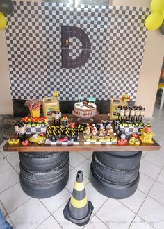 a table topped with lots of cakes and desserts next to a cone on the floor