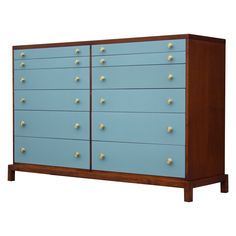 a blue dresser with gold knobs on the top and bottom drawers, against a white background