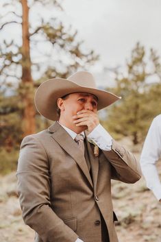 a man in a suit and hat standing next to another man