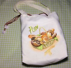 a white bag with an image of mushrooms and bread on it sitting on a green checkered tablecloth