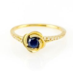 a yellow gold ring with a blue sapphire and diamonds