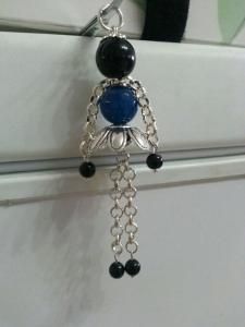 a pair of earrings hanging from the side of a refrigerator freezer with beads and chains attached to it