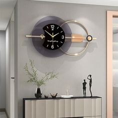 a clock on the wall above a dresser in a room with grey walls and flooring