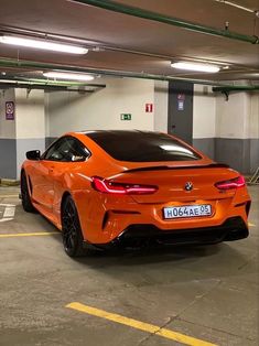 an orange sports car parked in a parking garage