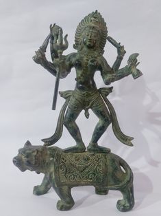 a statue of a man riding on the back of a bear and holding a spear