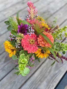 One of the many we offer for summer weddings, events, birthdays or just because.  This lovely bouquet contains salmon zinnias, green bells of Ireland, yellow sunflowers, purple dahlias, pink celosia and purple statice. Sunflower Market Bouquet, Zinnia Sunflower Bouquet, Sunflower And Zinnia Bouquet, Zinnia Boutonniere, Zinnias Bouquet, Zinnia Wedding Bouquet, Christmas Ideas Decoration, Hoco Bouquet